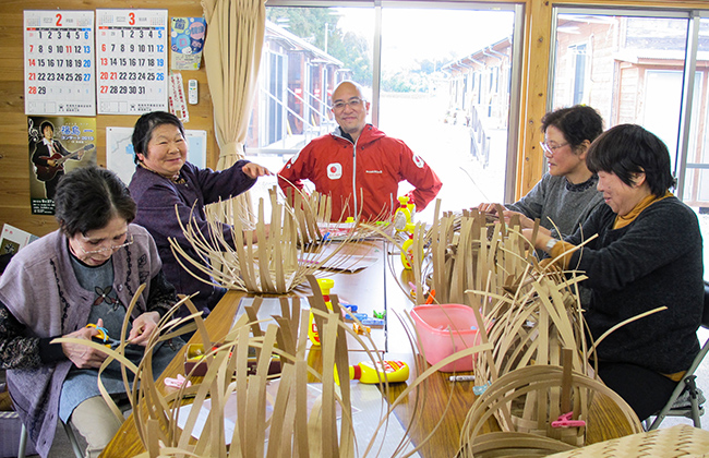 机で竹細工を楽しむ高齢の方々の写真