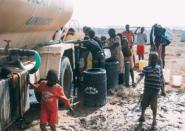 アフリカで給水車の近くに集まる人々