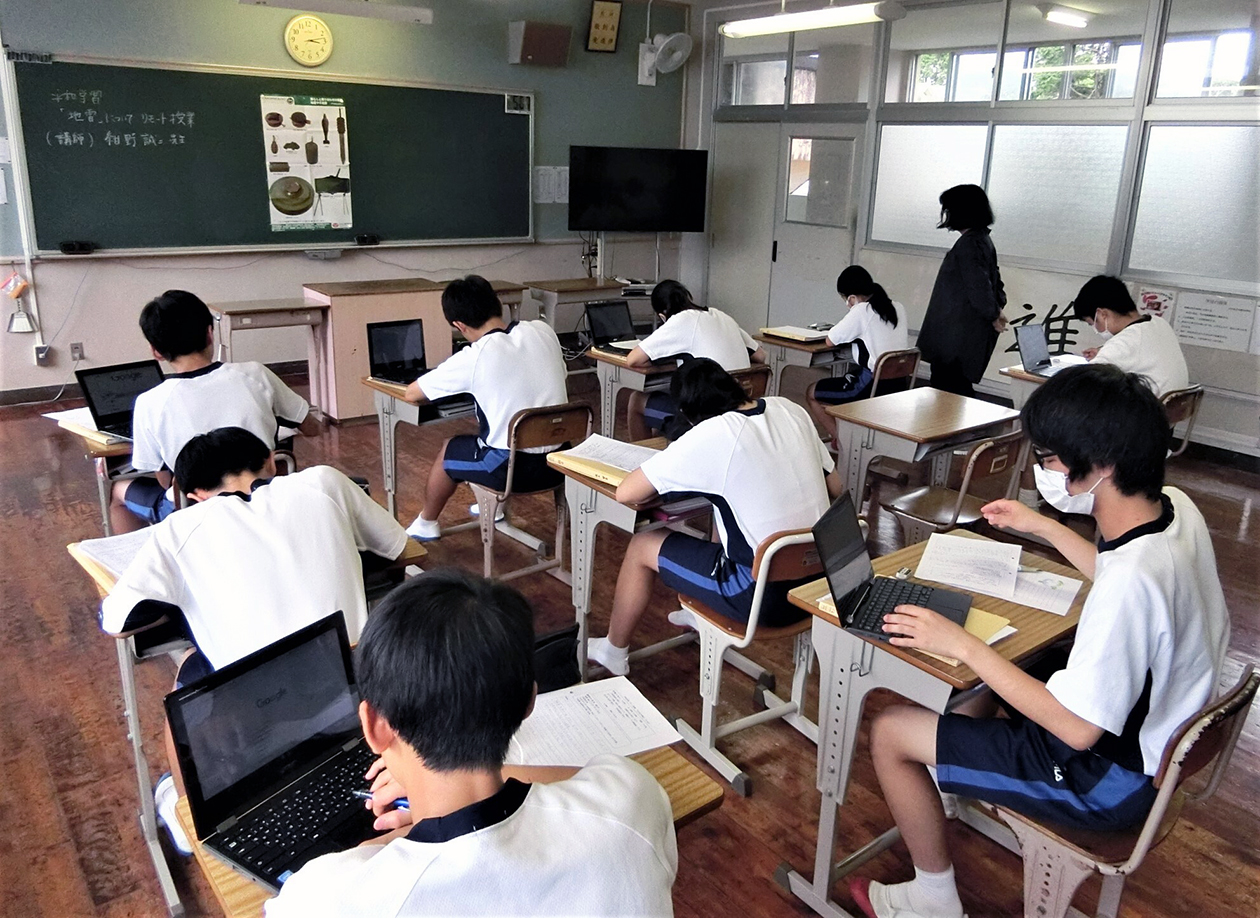 教室で子どもたちが机の上にノートパソコンを置き、勉強している