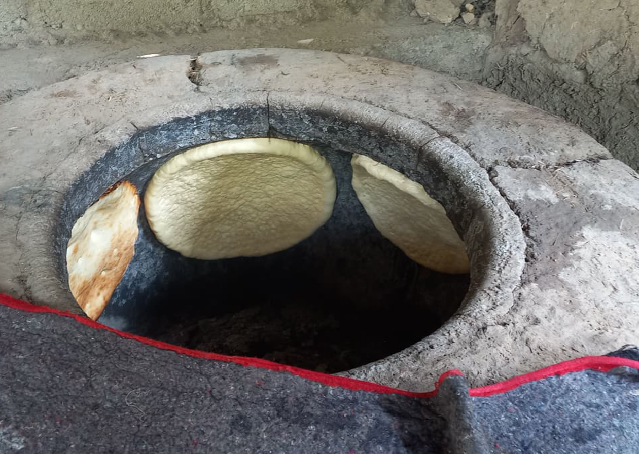 石窯の内壁にノンが貼られ、焼かれている。パッと見は井戸のような釜