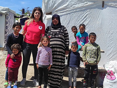 支援物資を届けたトルコ地震被災者の家族とAARスタッフの集合写真。お母さんが中央で、その周囲に子どもたち6人