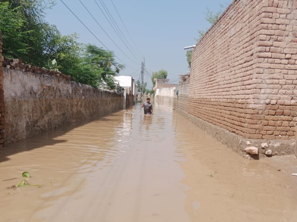 浸水した道路を男性が歩いている