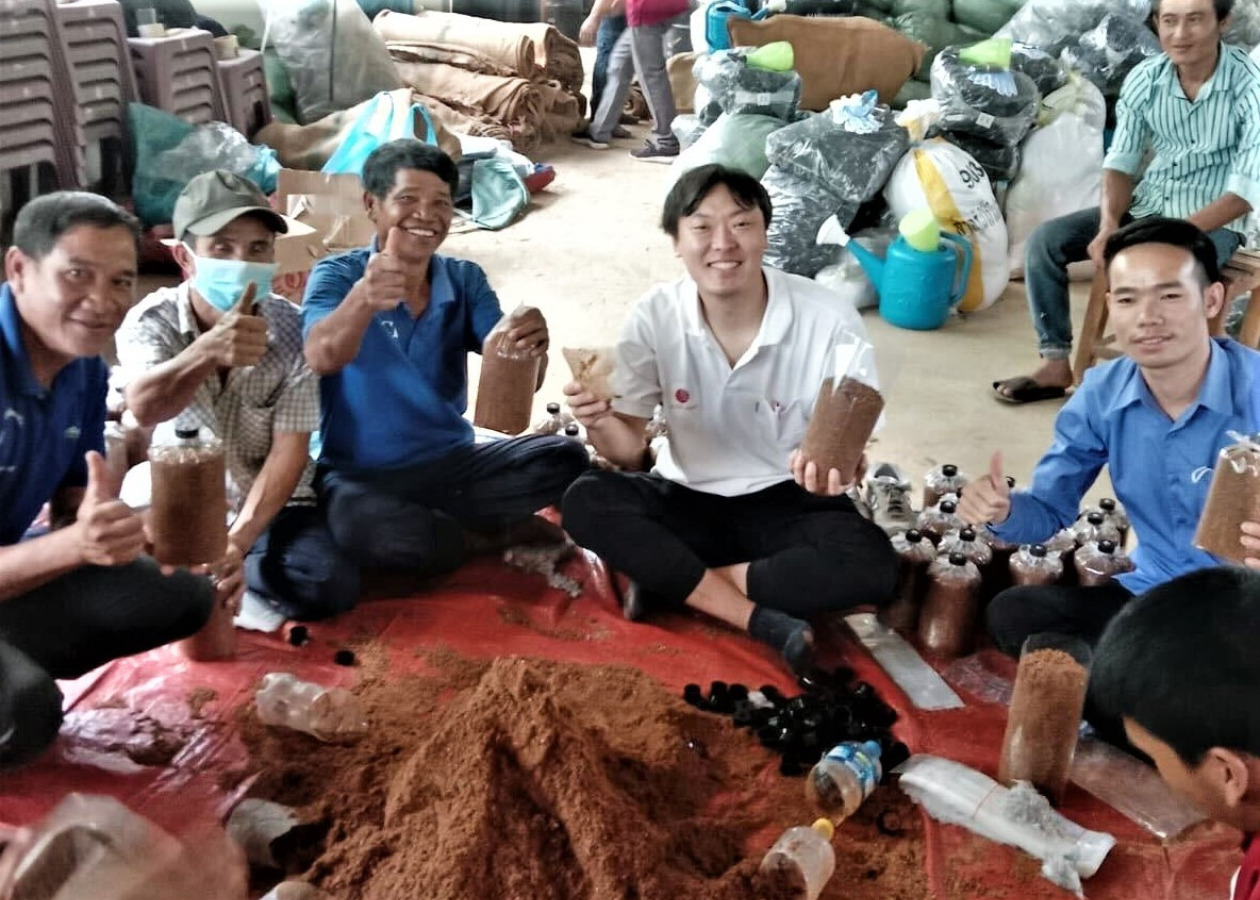 キノコ栽培研修の参加者とAAR職員の峯島昂佑（中央）の写真