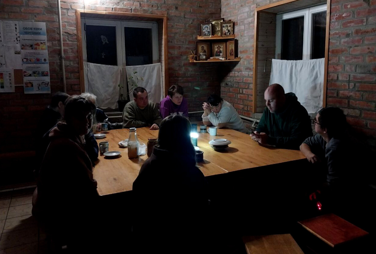 小さな灯を頼りにミーティングするジェレラのメンバー＝ウクライナ・ボフスラフ市にある同団体の施設での写真（ジェレラ提供）