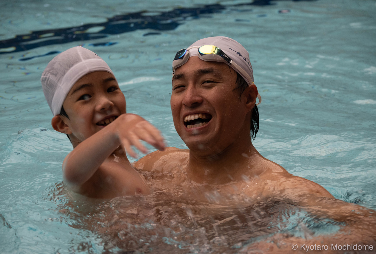 プールの中で楽しそうに笑う子どもと木村さんの写真
