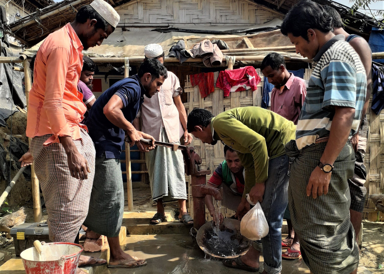 難民キャンプで井戸の修理技術を習う男性たちの写真