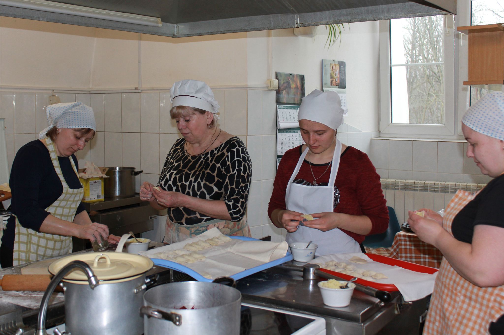 修道院のキッチンで、４人のウクライナの女性が、ヴァレニキを包んでいます