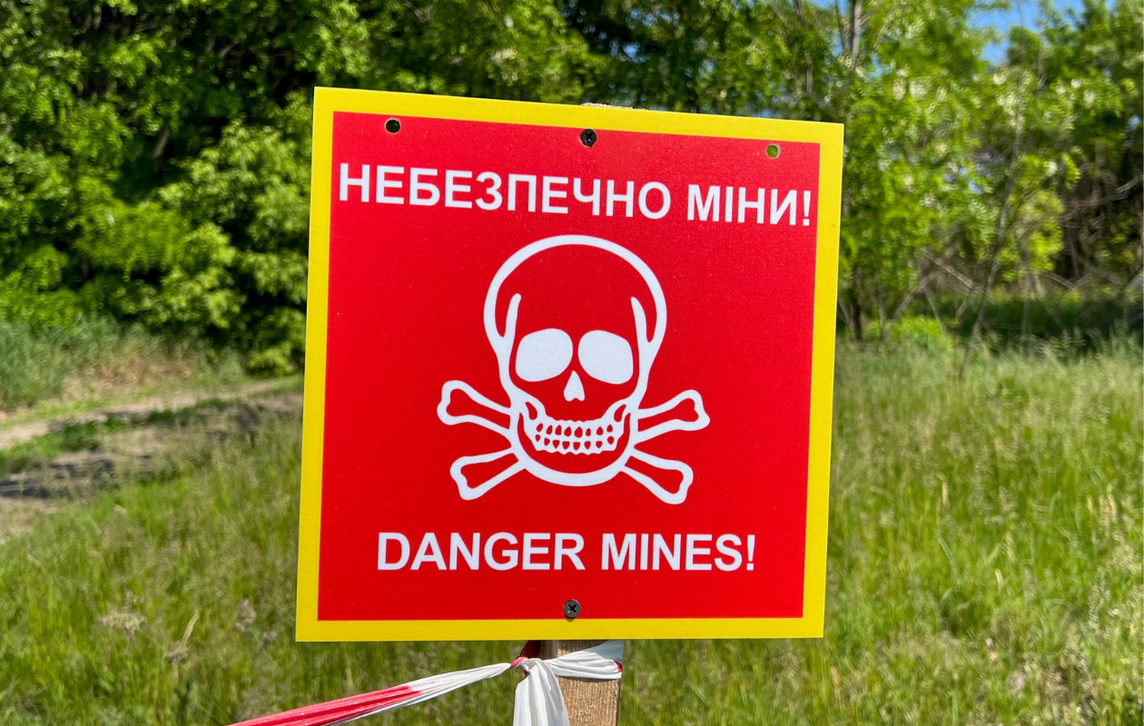 ウクライナにある地雷原があることを警告する看板の写真黄色い外枠に赤地白抜きで地骨のマーク。ヘイロートラストが撮影