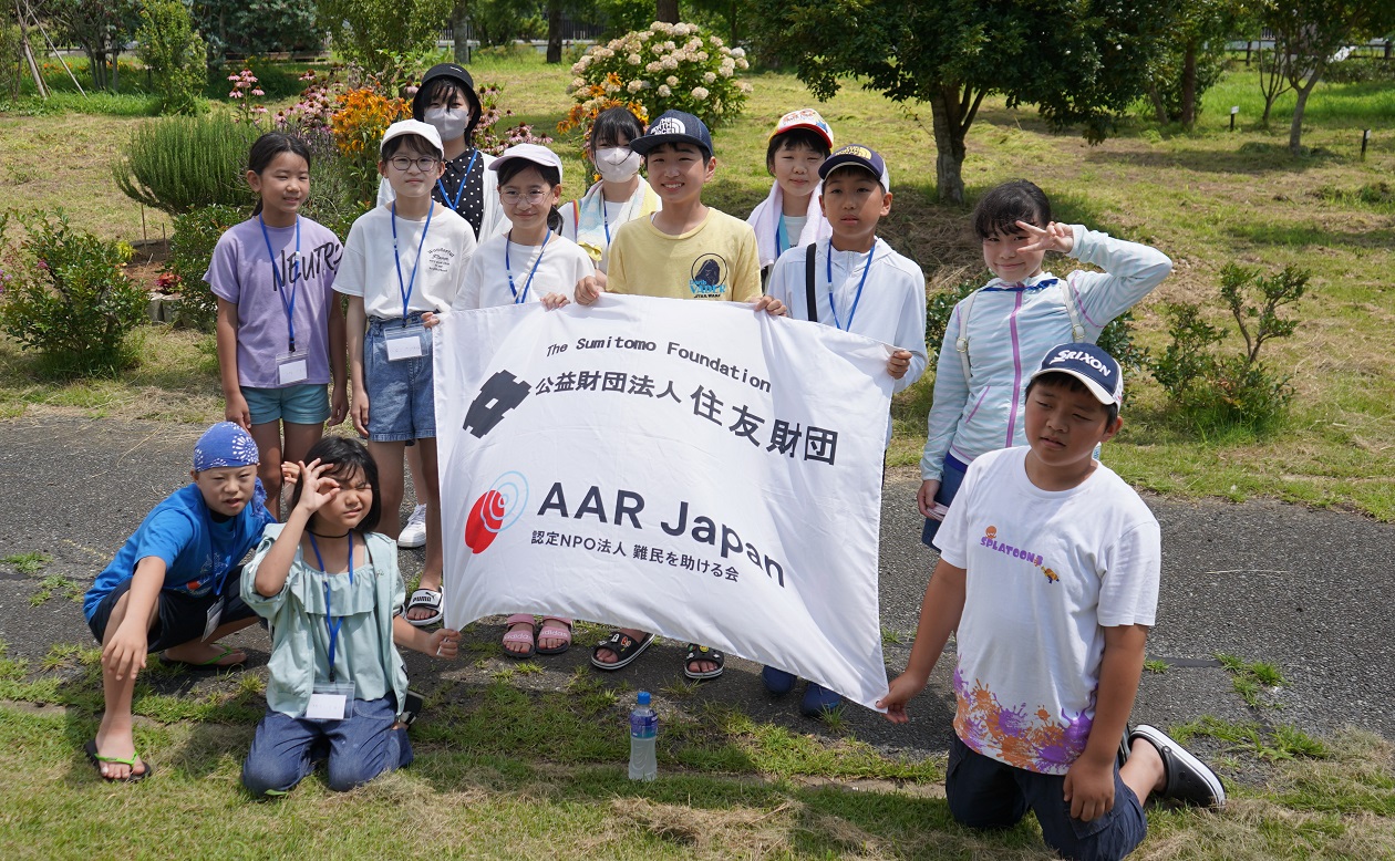 AARの旗を持って記念撮影する参加者の子どもたち