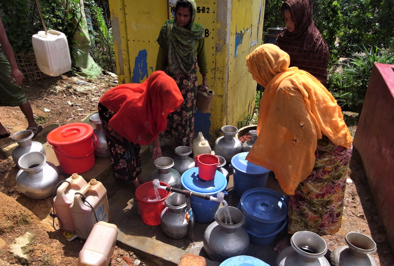 水汲み場でバケツやヤカンに水を汲んでいる女性たち