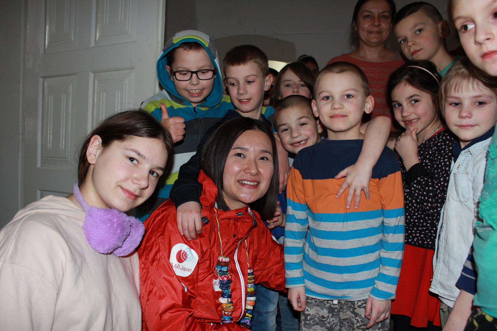 修道院に避難しているウクライナの子どもたちに囲まれた東マリ子職員。みんな笑顔です。