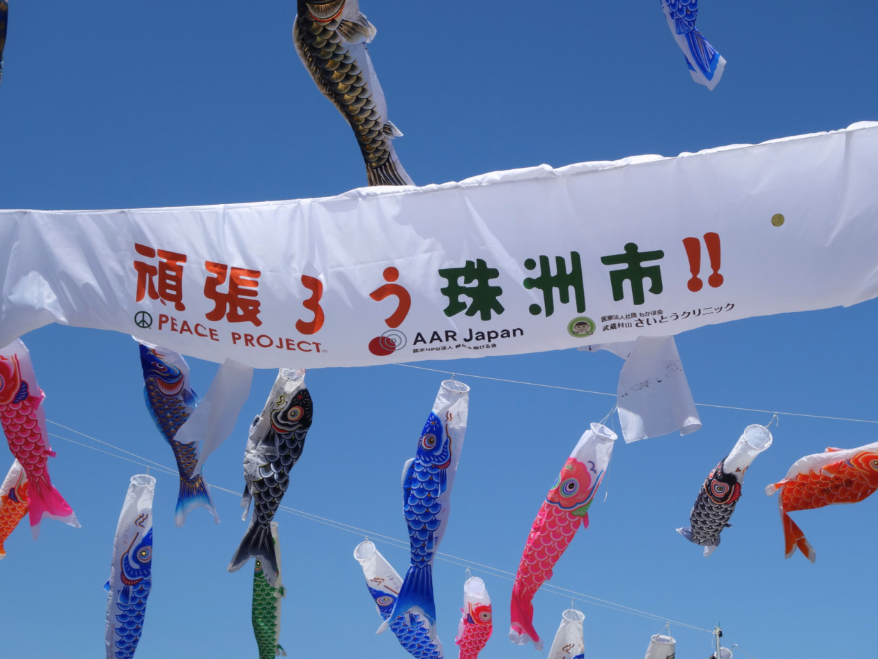 「頑張ろう珠洲市！」の文字とAARロゴが入った鯉のぼりが空に掲げられている