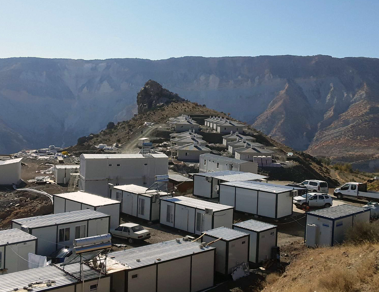 山に切り開かれた土地に、たくさんの白いコンテナや住居が立ち並んでいる。