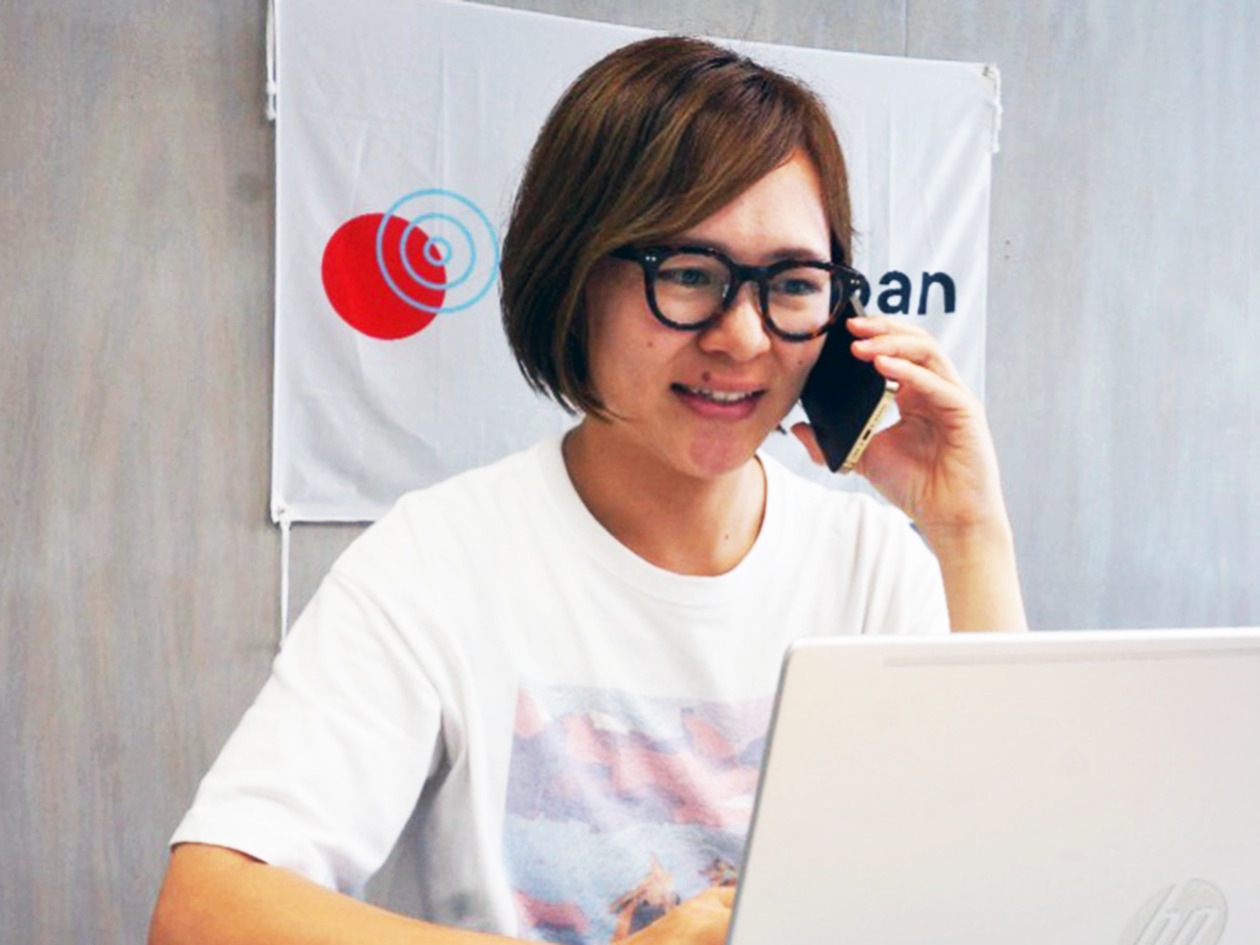 女性がパソコンを見ながら電話をしている