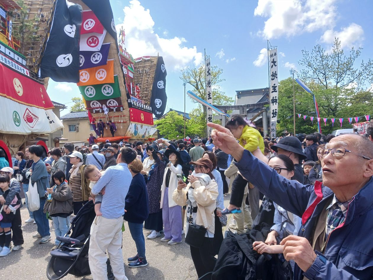 色とりどりの幕を垂らした山車が練り歩いている