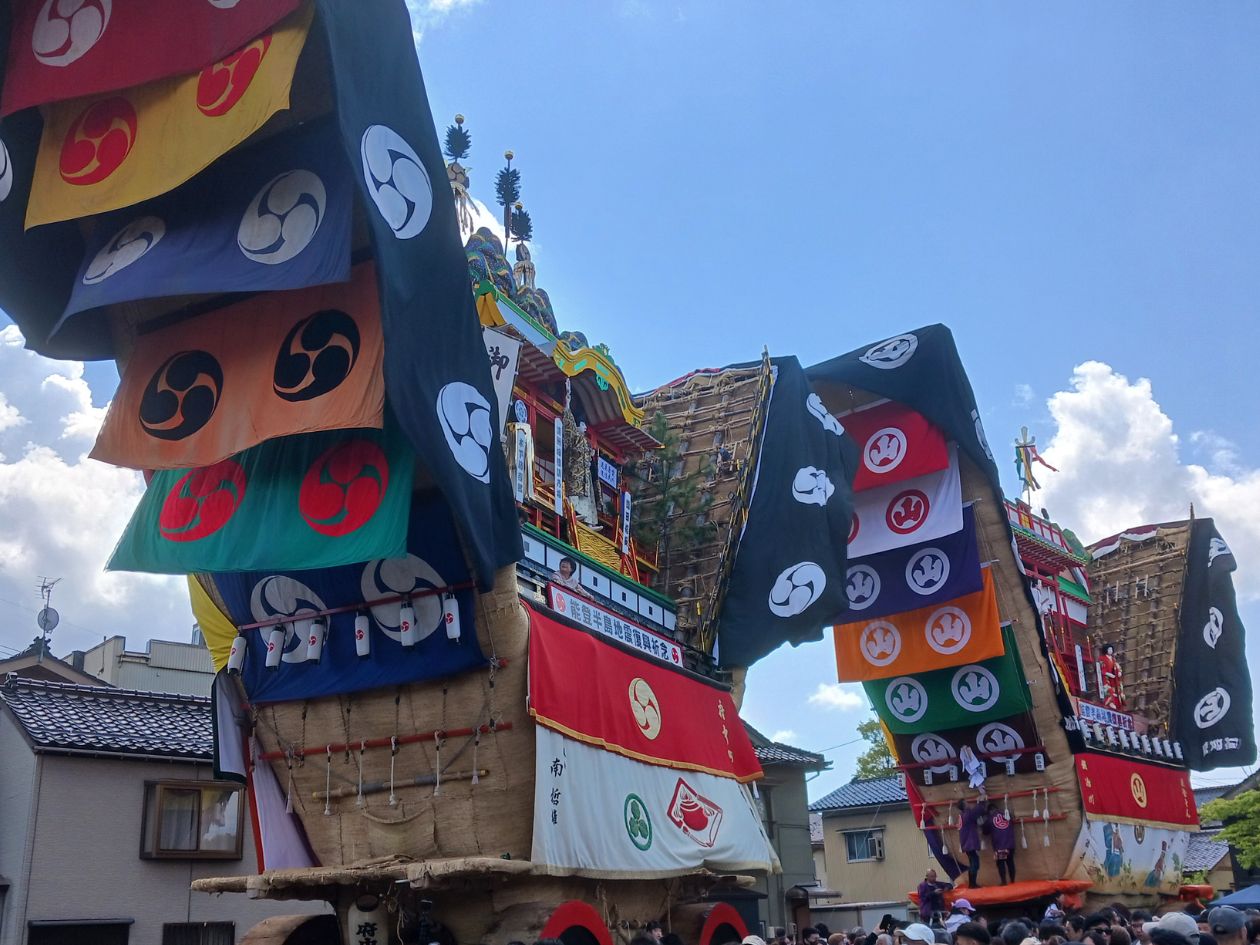 色とりどりの幕を垂らした山車が練り歩いている