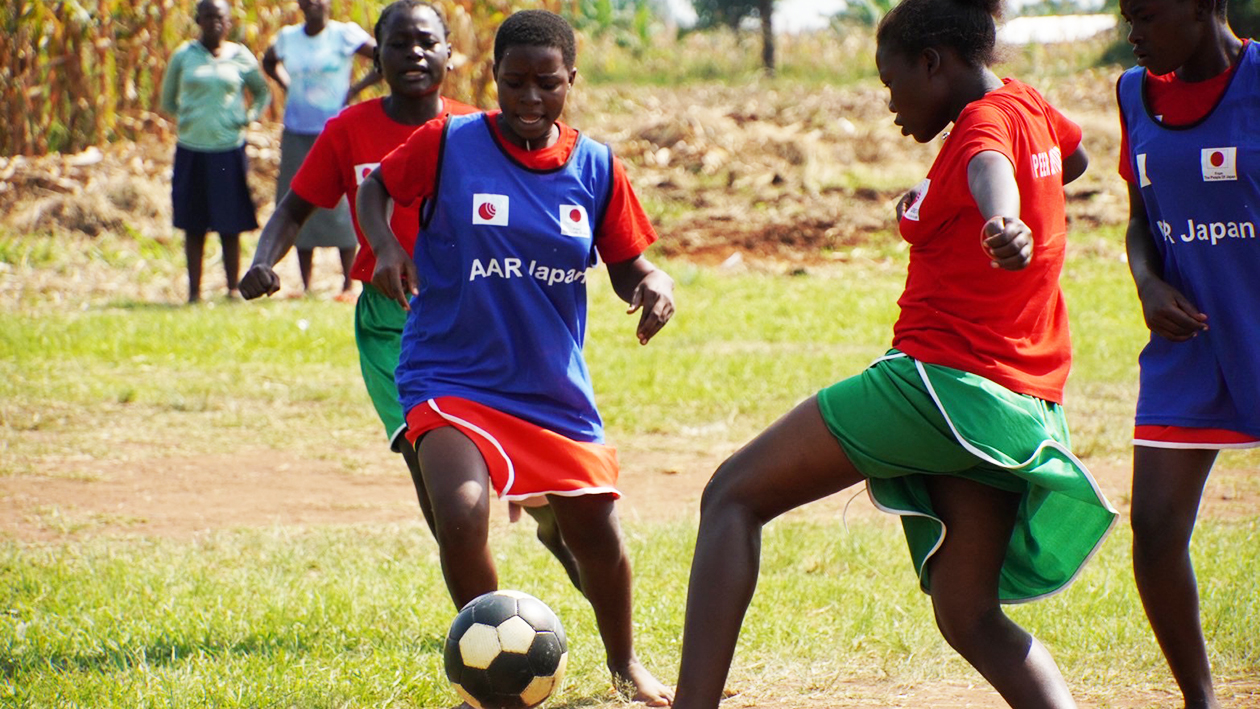 草原で裸足でサッカーをしている様子