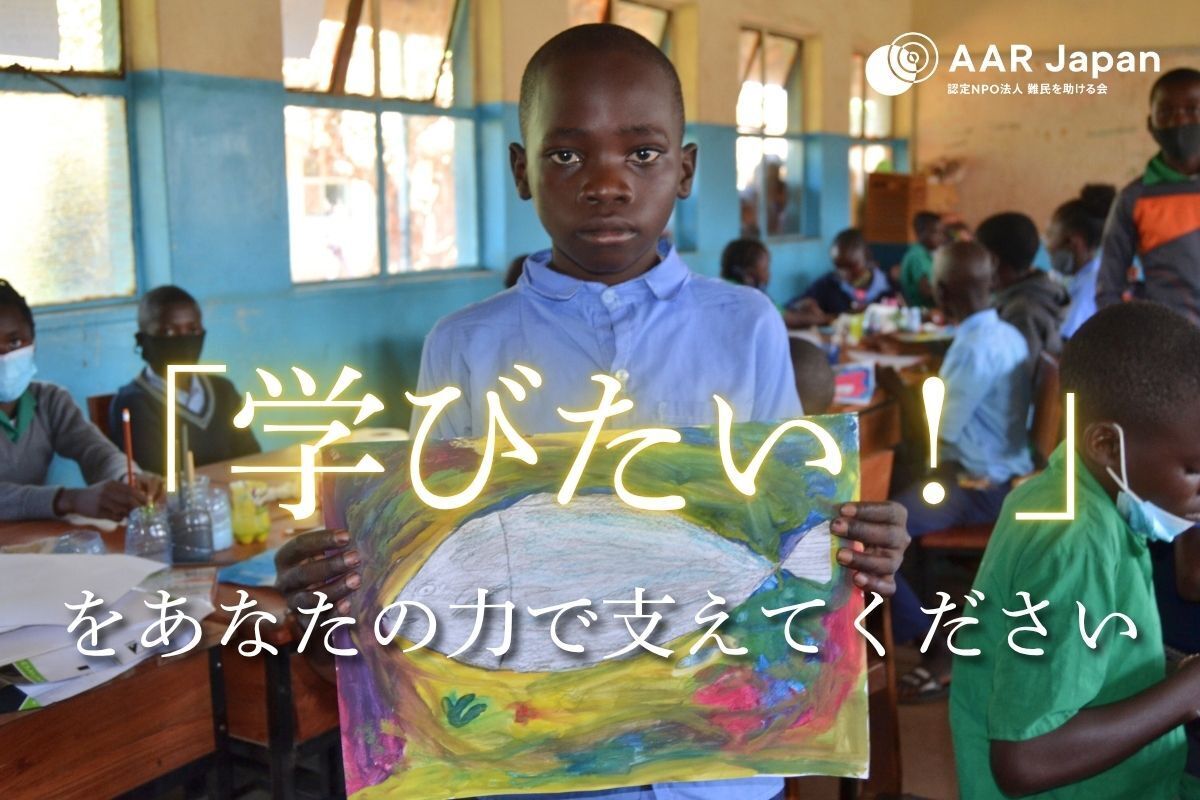ザンビアの学校で自分の描いた絵を手にする子ども
