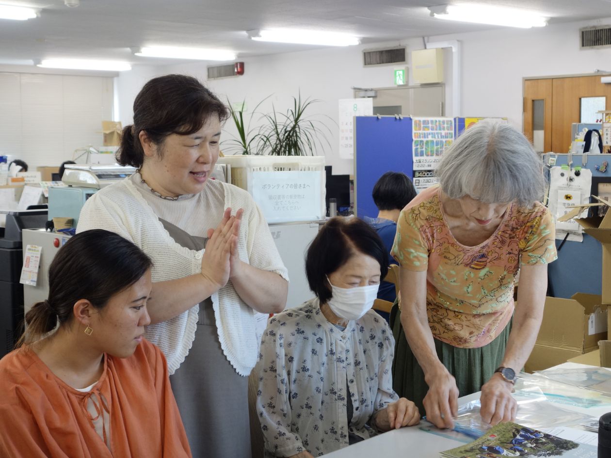 前田が作業をする女性たちに笑顔で話しかけている