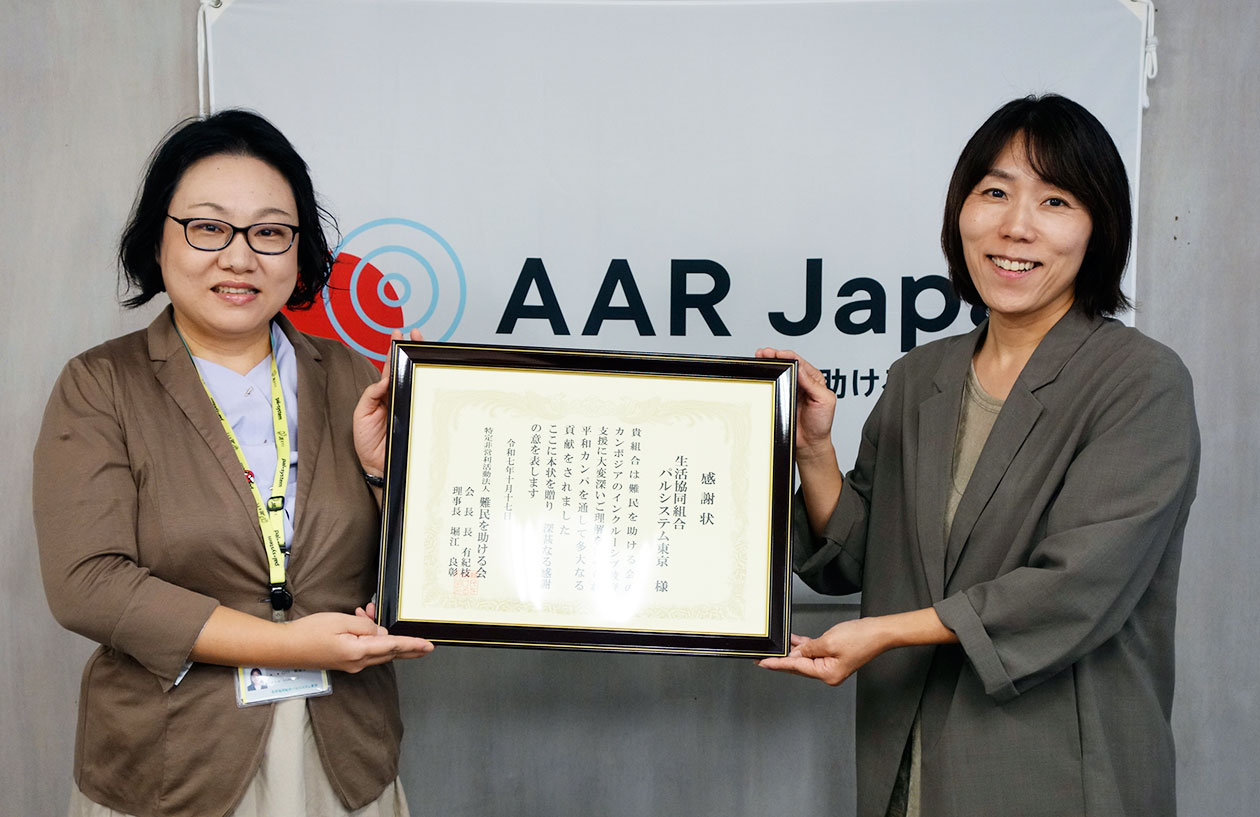 二人の女性が感謝状を手にして笑顔で立っている