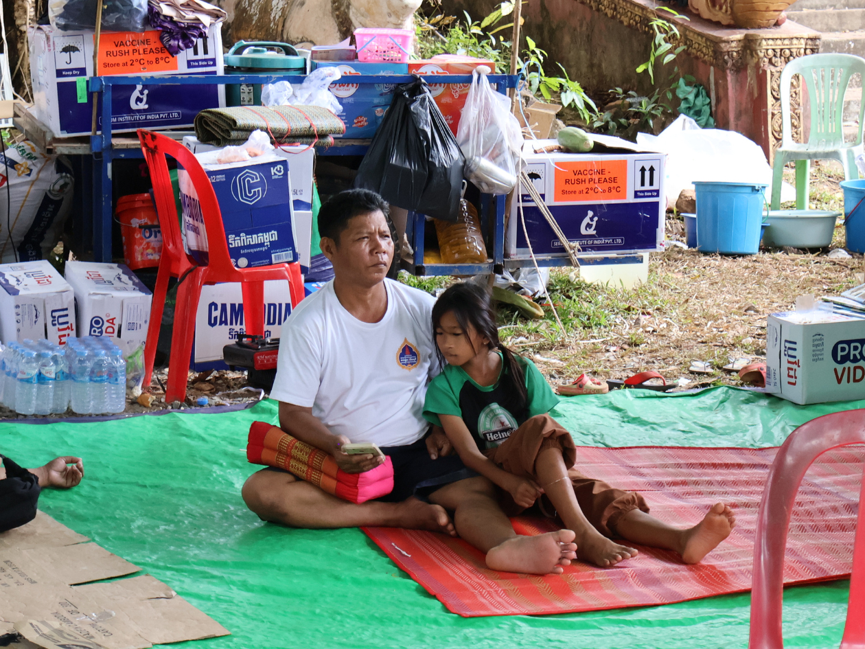 シートの上に父親と娘が寄り添うように座っている