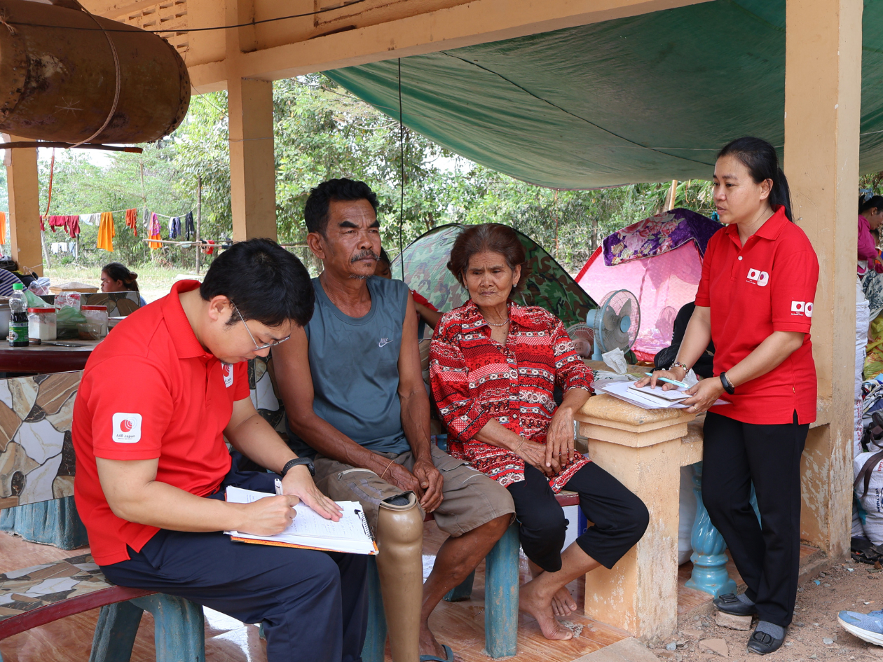 夫婦の隣で男性が話を聞きながらメモを取っている