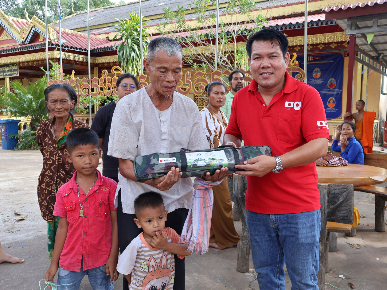 男性がテントを手渡している