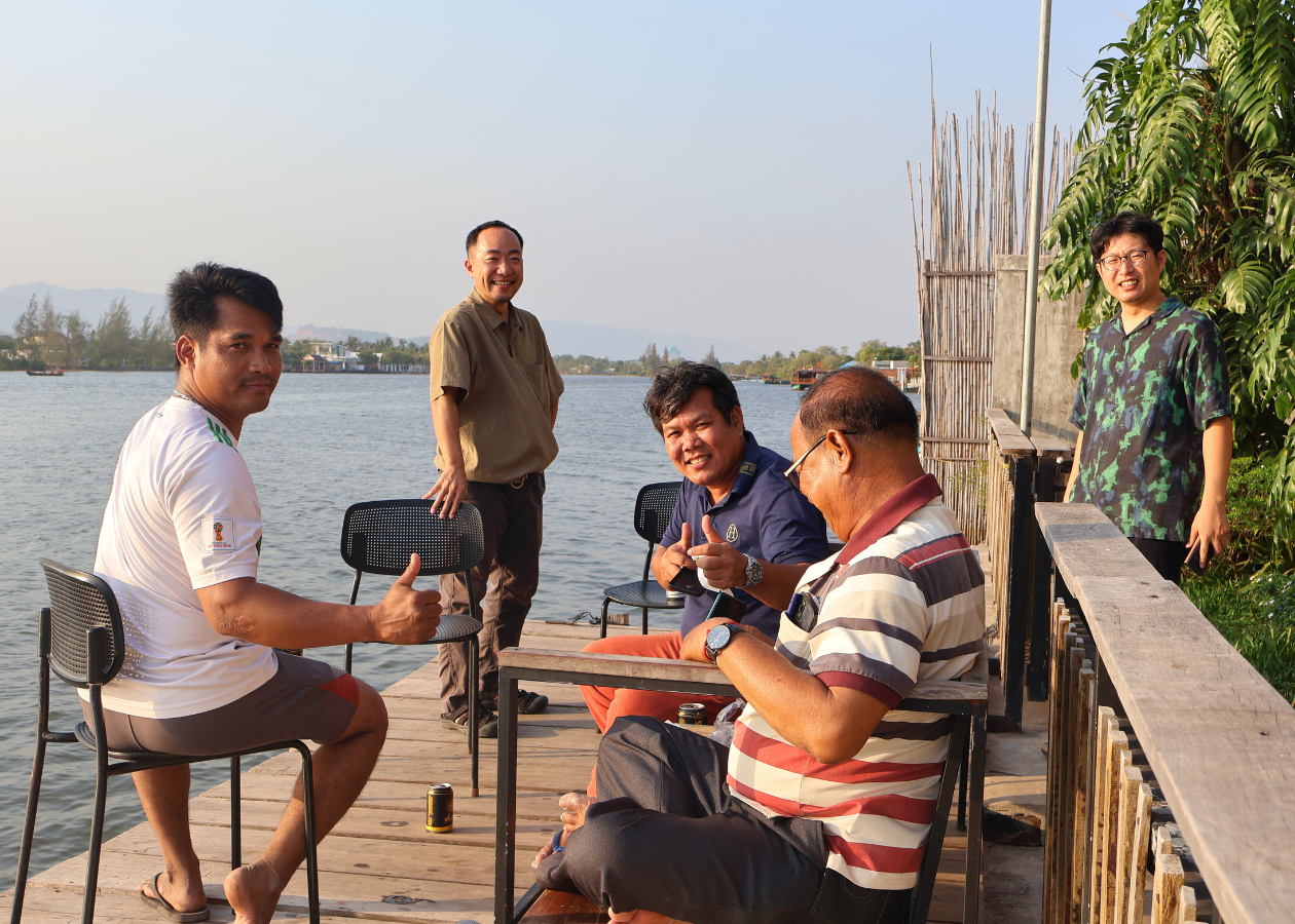 川辺で男性たちが談笑している