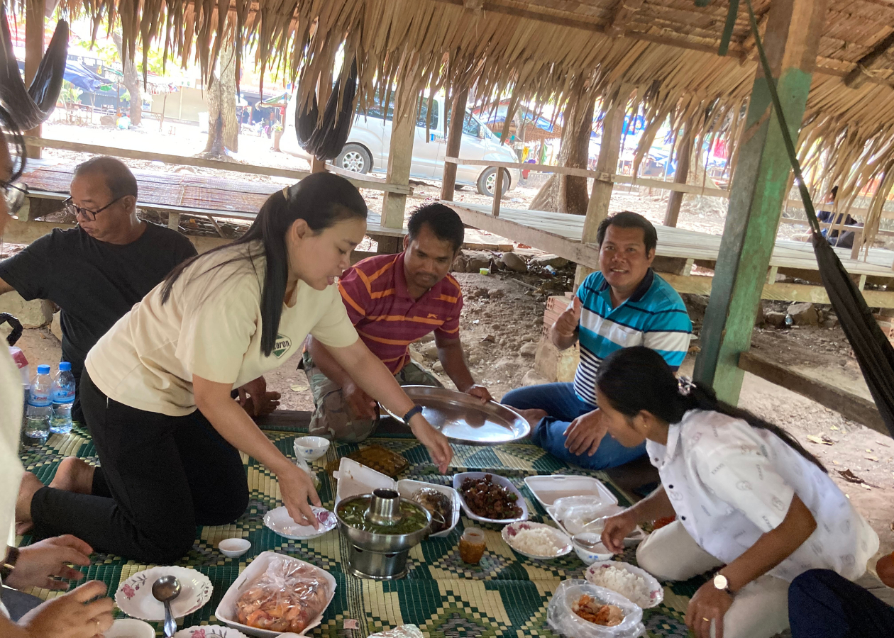 野外のテーブルで、男女が食事の準備をしている