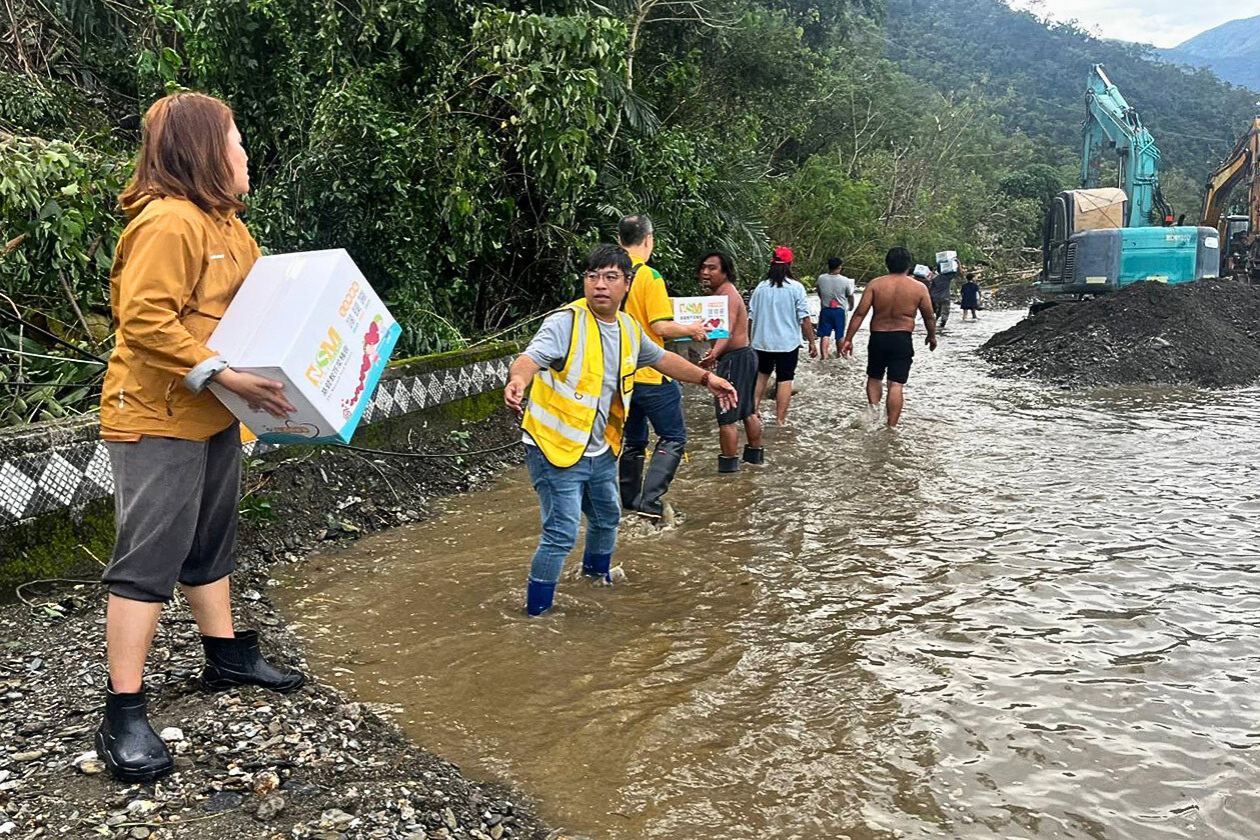 長く連なって支援物資を運ぶMSMスタッフ