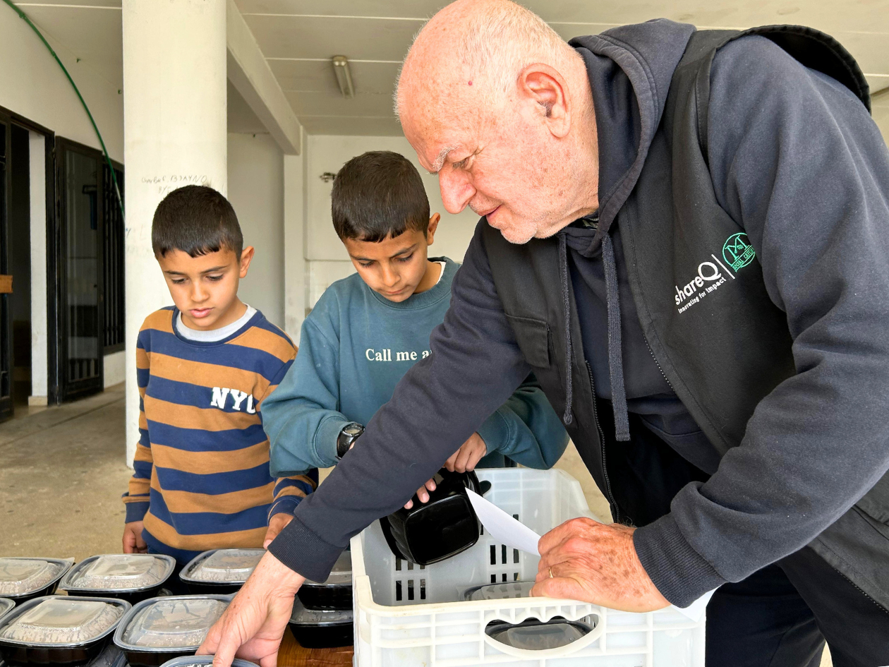 協力団体スタッフから食料を受け取る子ども2名