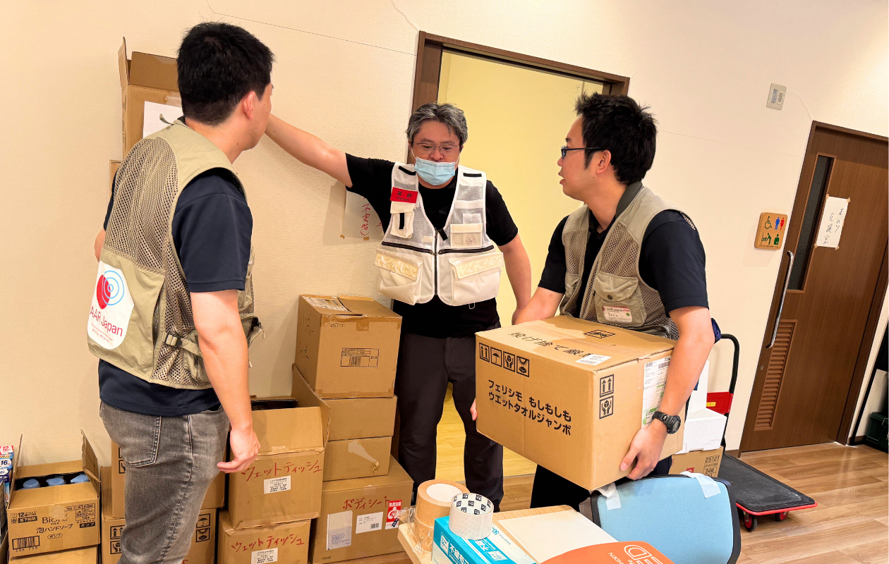 支援物資が入った段ボールを持つAAR職員