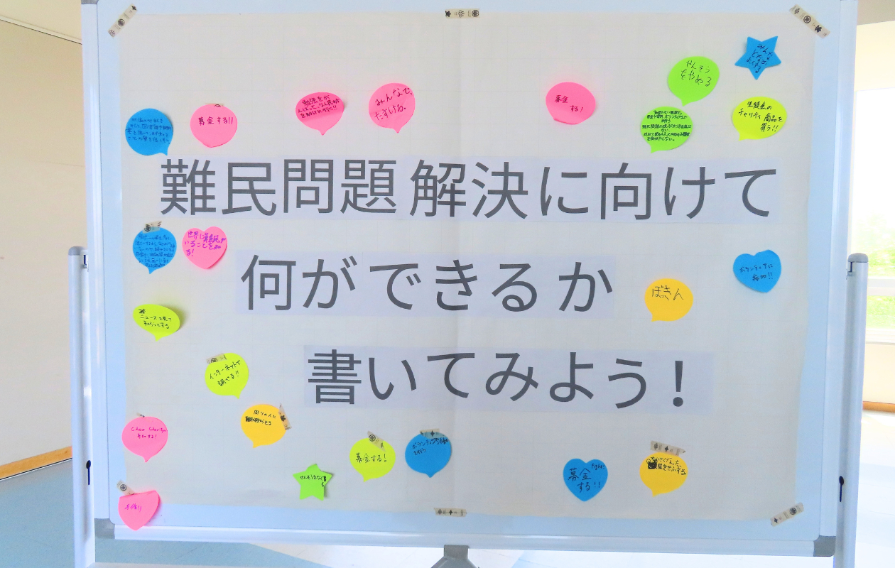 ホワイトボードに「難民問題の解決に向けて何ができるか書いてみよう！」という大きな文字と、カラフルな付箋