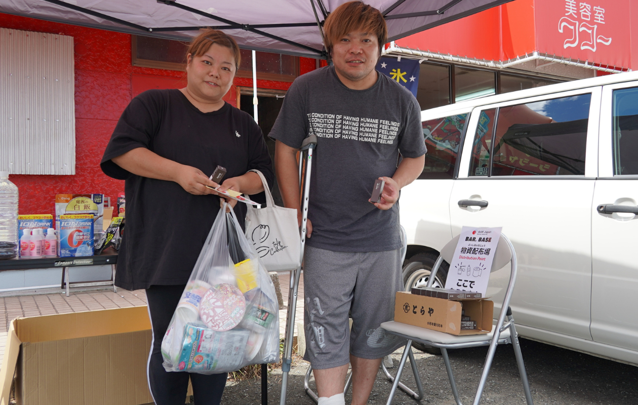 羊羹を受け取った2人。1人は松葉杖をついている。